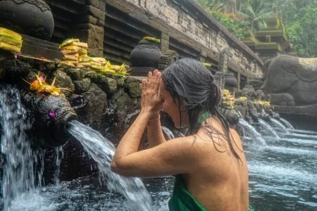 a woman in a green dress in a pool of water. Bali, Indonesia at Mengening Temple
