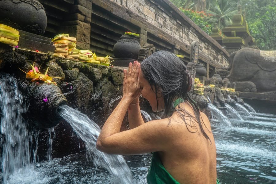 a woman in a green dress in a pool of water. Bali, Indonesia at Mengening Temple