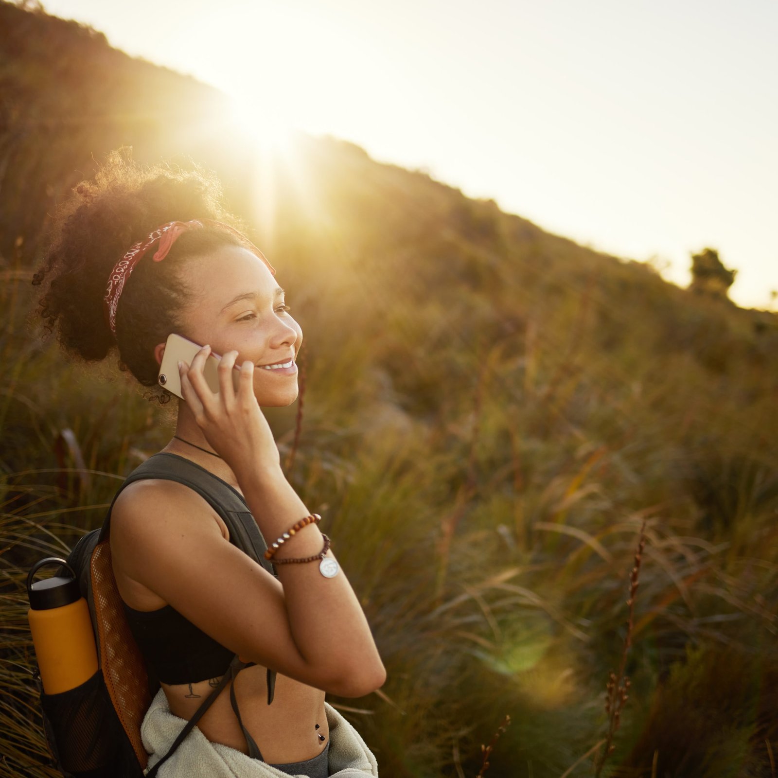 a woman talking on a cell phone in a grassy area